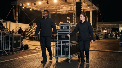 Event crew moving flight cases to a stage with Maine Couriers